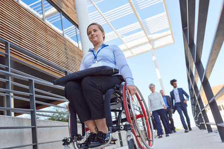 Femme se déplaçant sur un fauteuil roulant.