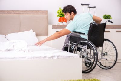 Personne en fauteuil roulant dans une chambre spécialement aménagée pour les personnes PMR.