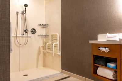 Salle de bain avec douche adaptée à une personne à mobilité réduite.