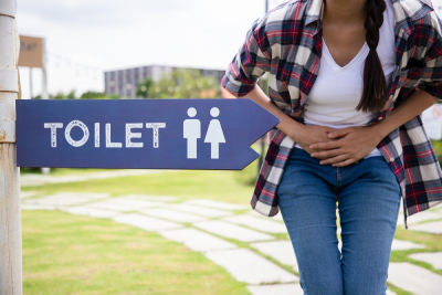 Une femme souffrant d'incontinence urinaire se dirigeant vers les toilettes
