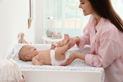 Une maman qui change la couche de son bébé.